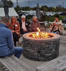 a group of people sitting around a fire pit